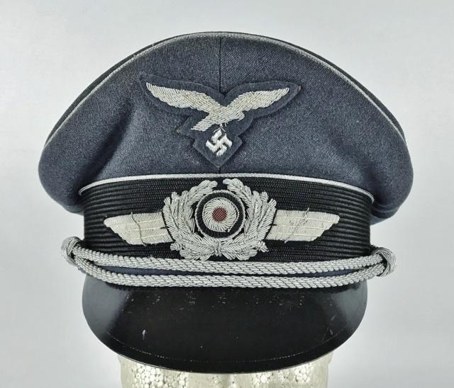 WW2 German Luftwaffe Officer Visor Cap, EREL: World War Two German Luftwaffe Officer visor cap. High quality blue - grey wool construction with mohair band, braided silver bullion piping, adjustable silver bullion chin cord secured with two non m