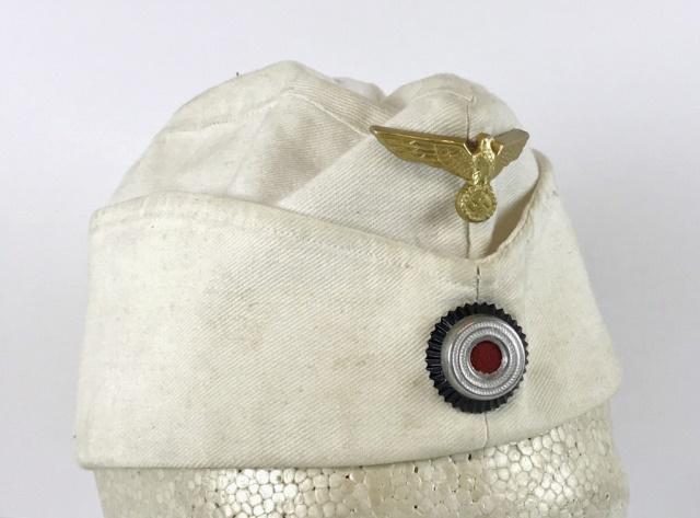 WW2 German Kriegsmarine EM / NCO Overseas Cap: World War Two German Kriegsmarine EM / NCO overseas cap. Constructed of white cotton twill with two piece die struck metal insignia, eagle over cockade. Excellent field worn condition with light soili
