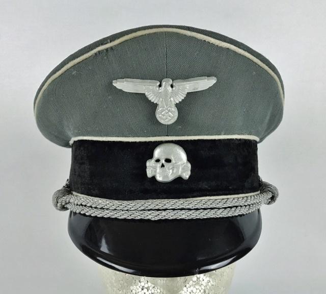 WW2 German SS Officer Visor Cap: World War Two German SS Officer Visor Cap. Constructed of tricot grey wool with black velvet band and white piping with silver bullion chin cord and black lacquered vulcanfibre visor. Cap with die str