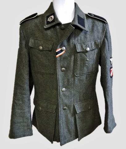 WW2 German SS Latvia Legion EM Field Tunic: World War Two German SS Latvian Legion EM Field Tunic. Green-grey wool construction with four pocket, five button front closure. Interior partially twill lined with numerical depot stamps in ink. Insi