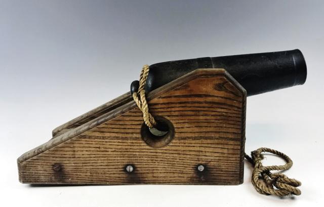 19th C. Ship's Signal Cannon: Circa 1850 cast iron cannon mounted to a wooden "sled" style carriage. Iron cannon tube measures 13" L, Muzzle 2.75 D and Bore 1.9" D. Hand made wooden carriage with sloping sides fitted to trunions a