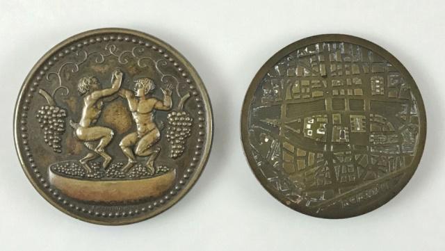 Art Deco Medals Dionysus & La Cite (2pc): Two Art Deco Medals Dionysus and La Cite. (1) Society of Medallists Bronze "Dionysus Medal" by Paul Manship. Obverse features the head of Dionysus facing left, wearing an ivy wreath & grape bunches in