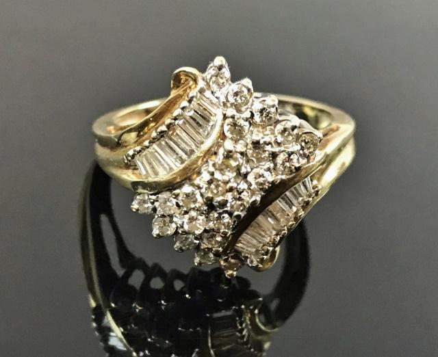 Ladies 14K Gold, Diamond Ring: Vintage ladies 14K gold and diamond ring. Crafted of 14K yellow gold, set with twenty-two well matched round cut diamond melee flanked by sixteen baguette diamonds. Ring size: 10, Total assembled weig