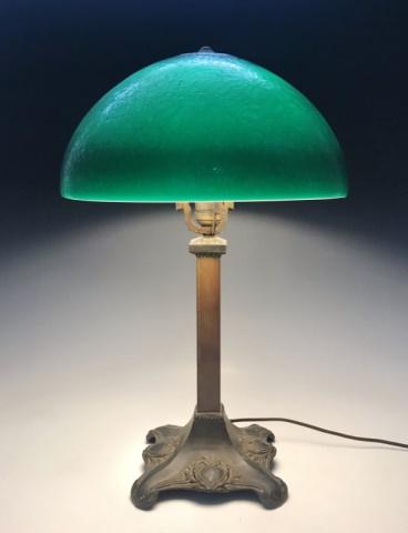 Antique Green Glass Shade Table Lamp: Early 20th C. Table Lamp. Bronze base with single socket and green textured glass shade. Lamp in excellent working condition, measures: Base, 23" H 8" W x 8" D. Shade is 14" in diameter.