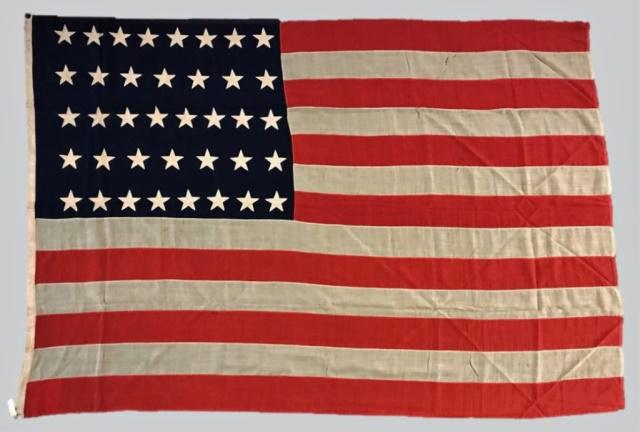 19th C. 38 Star American Flag, 1877-1890: 19th C. Thirty-Eight Star American Flag, (1865-1869). Treadle sewn multi piece wool construction with hand sewn "Peek-a-Boo" style stars in 8-7-8-7-8 linear pattern. Canvas hoist stamped in ink, "6" w