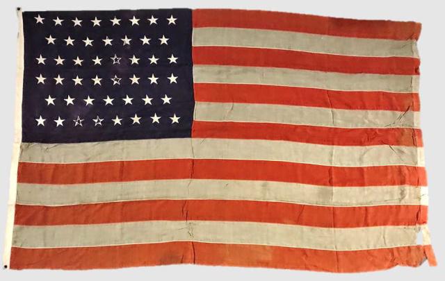 20th C. 46 Star American Flag, 1908-1912: 20th C. Forty-Six Star American Flag, (1908-1912). Sewn multi piece wool construction with sewn zigzag applique stars in 8-7-8-8-7-8 offset linear pattern. Canvas hoist marked "46 Stars" in black ink 
