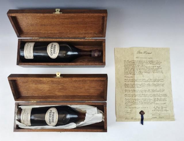 Bottles French Cognac, Ferrand Ancestrale (2pc): Two Cased Bottles of French Cognac, "Pierre Ferrand Ancestrale 1st Cru De Cognac", sealed with contents. Clear glass bottle with foil seal and paper labels, bottles accompanied by fitted wooden boxes.