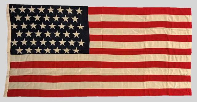 19-20th C. 45 Star American Flag 1896-1908: 19th - 20th C. Forty-Five Star American Flag, (1890-1896). Sewn multi piece wool construction with printed stars in 8-7-8-7-8-7 offset linear pattern. Canvas hollow hoist with collection inventory num
