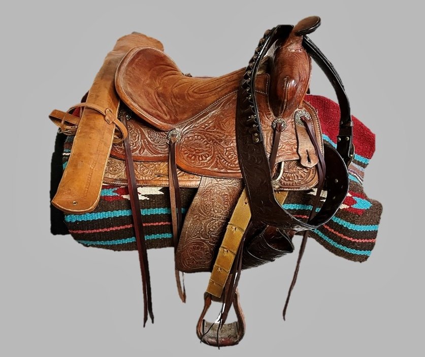 Vintage Tooled Leather Western Saddle, Gun Belt: Vintage Hand Tooled Leather Western Saddle. Fully rigged saddle with tack and stirrups. Hand tooled with foliate decoration throughout. Saddle accompanied by blanket and hand tooled leather gun belt a