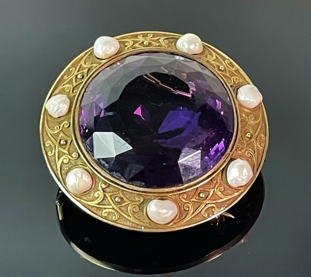 Large 19th C. Russian 14K Gold, Amethyst Brooch: 19th C. Russian 14K Gold and Amethyst Brooch. Heavy 14K yellow gold construction with double hinged pin reverse. Large cut center amethyst of exceptional quality,1.65" D. Gold frame with hand chased s