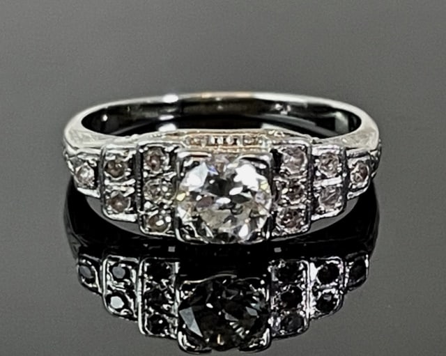 Antique Ladies 18K Gold, Diamond Art Deco Ring: Antique Art Deco 18K Gold and Diamond Ring. 18K white gold ring set with center round cut diamond of approximately .75 cts, evaluated as I-J color and SI 1 clarity, flanked by twelve small well matche