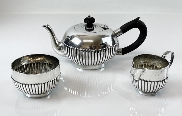1784 English George III Sterling Teaset (3pc): English George III Sterling Silver Teaset. Three piece set with teapot, creamer and sugar with ribbed decoration and London hallmarks, 1784 date letter and maker mark "PJ". Good condition with wear an