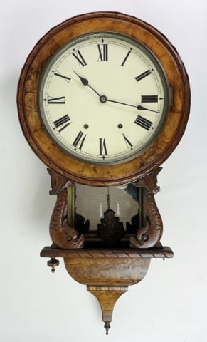 Antique Wall Clock Carved Dolphin Case: 19th C. Wall Clock with Carved Figural Case. Walnut and burl wooden case with hand carved dolphin decoration, Roman Numeral radial face. Good condition, working, measures: 33" H x 16.5" W.