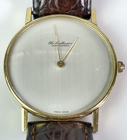 Men's Swiss Dress Watch, Ole Mathiesen: Vintage Men's Swiss Dress Watch, Signed "Ole Mathiesen". Silvered face with hour and minute indicator hands, leather band. Good condition, case measures: 1.3" D.
