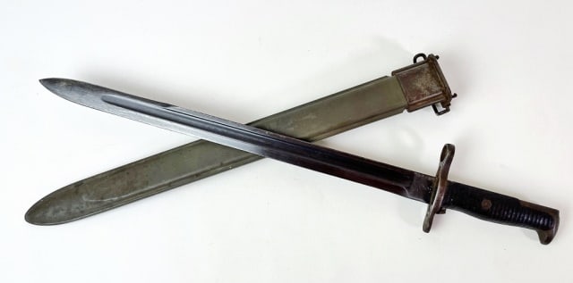 WW1 US Springfield Bayonet, 1908: WW1 U.S. Springfield Baronet. Single fullered blued steel blade with ricasso marked "SA 1908" with textured wooden grips and steel gaurd and pommel. WW2 fiberglass sheath with flaming bomb. Good condi