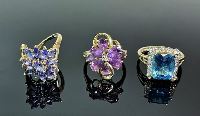 Three Ladies 14K Gold and Gemstone Rings (3pc): Collection of Three 14K Gold Gemstone Rings: (1) 14K yellow gold ring, prong set with center cushion cut tanzanite stone with diamond surround, (1) 14K yellow gold ring, set with facet cut gemstones i
