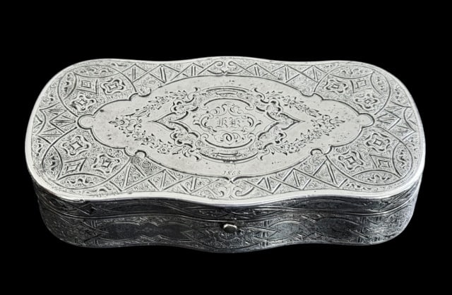 1865 Dated Continental Silver Snuff Box: 1865 Dated Continental Silver Snuff Box. Hinged lid with button latch. Surfaces profusely decorated with geometric and scroll hand chased designs, center cartouche with "KK" monogram, interior gold wa