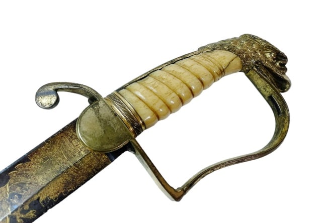 War of 1812 American Eagle Head Sword, Cavalry: War of 1812 Era American Eagle Head Cavalry or Mounted Artillery Officer's Sword. Curved single fullered curved blade with blued and gilt decoration of foliate, patriotic and military themes. Gilt bra