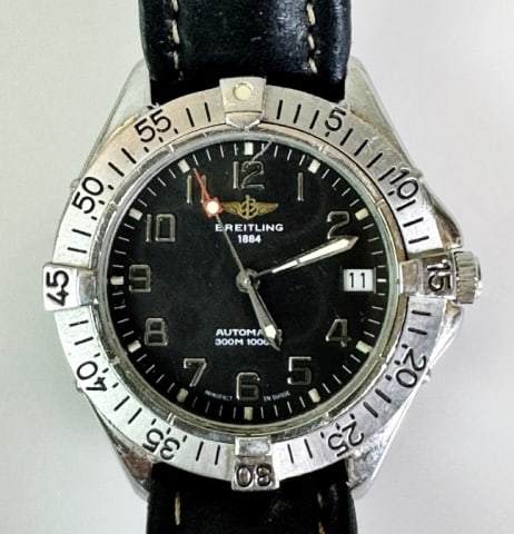 Vintage Swiss Automatic Watch, Breitling 1884: Vintage Swiss Automatic Men's Watch, Signed "BREITLING 1884" and "AUTOMATIC 300M 1000FT" Stainless steel case with moveable bezel. Black face with Arabic Numeral radial dial with date function. Good r