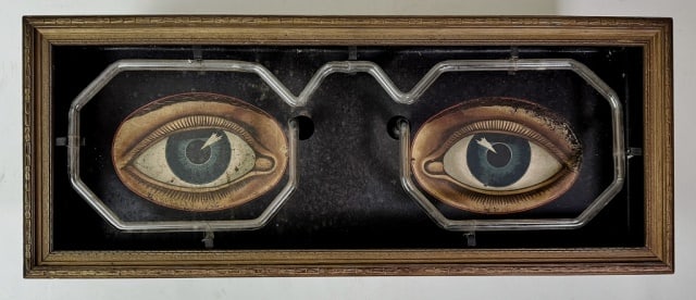 1920's Neon Optometrists Trade Sign: 1920's Neon Trade Sign for an Optometrist. Tin sign with hand painted eyes, framed by orange neon. Excellent working condition, measures: 9.5" H x 23.5" W x 6.25" D.