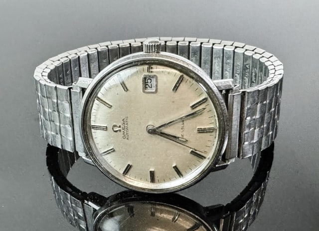 1960's Men's Swiss Automatic Wristwatch, Omega: 1960's Men's Automatic Wristwatch, Signed "OMEGA DEVILLE". Stainless steel case and band with automatic Swiss movement. Champagne face with baton style radial dial with sweep seconds and date window.