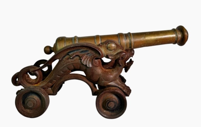 Antique Brass Signal Cannon: 18th - 19th C. Brass Signal Cannon. 18th C. Brass multi-stage ringed tube with flared muzzle and round trunions. Later cast iron wheeled carriage with figural winged dragons. Excellent condition, meas