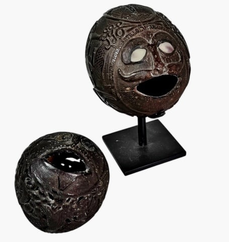 Antique Mexican Hand Carved Coconuts (2pc): Two Antique Prisoner Hand Carved Coconut Banks, Castillo de San Juan de Ulua. Profusely relief carved with Native Mexican themes, flora, fauna and mythological beasts. One carved with banner, "RECUERD