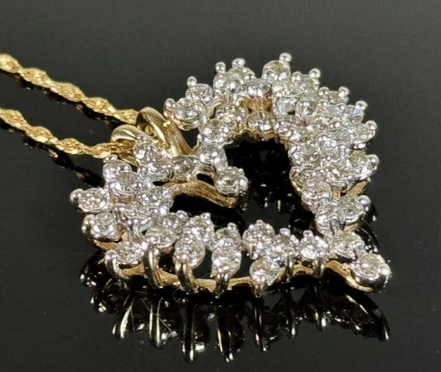 14K Gold Diamond Heart Pendant and Chain: 14K Gold and Diamond Heart Pendant Necklace. Pendant crafted of 14K yellow gold set with fifty round cut well matched quality diamonds, with stylized 14K yellow gold chain. Good condition, pendant mea