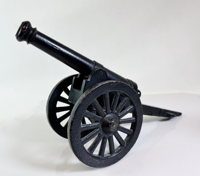 Antique Cast Iron Signal Cannon: Antique Cast Iron Signal Cannon. Cast iron tube with trunions on a spoke wheeled carriage, surfaces in old black paint. Good condition, measures: 9.25" H x 16.5" L