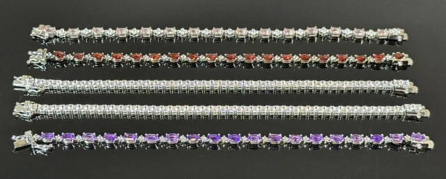Sterling Silver Gemstone Bracelets (5pc): Five Sterling Silver Gemstone Tennis Style Bracelets: (2) Sterling silver tennis bracelets with 48 small cubic zirconia stones,(1) Sterling silver tennis bracelet with 19 red gemstones and 19 cubic zi