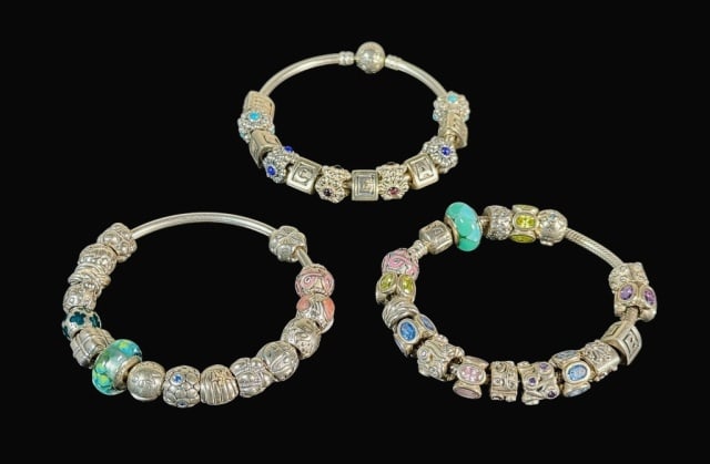 Sterling Silver Charm Bracelets, Pandora (3pc): Three Sterling Silver Pandora Charm Bracelets: (1) Rigid sterling silver bracelet featuring 6 silver letter charms and 6 sterling silver birthday blooms charms, (1) Rigid sterling silver bracelet feat