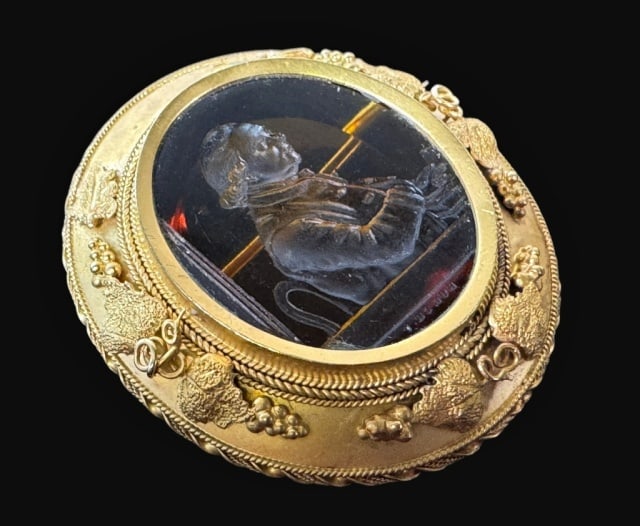 14K Gold Amber Intaglio Brooch: 14K Gold Amber Intaglio Brooch. Crafted of 14K yellow gold with bezel set polished amber panel with incuse carved portrait of an 18th C. gentleman in profile. Setting with grape and vine decoration in