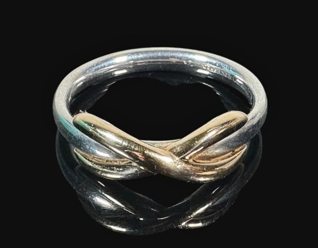 Sterling Silver, 18K Gold Ring, Tiffany & Co: Vintage Bi-metallic Sterling Silver and 18K Gold Ring. Sterling silver ring with 18K yellow gold knot form overlay. Ring accompanied by Tiffany & Co fabric bag. Good condition,weight: 3.6 g, Ring size