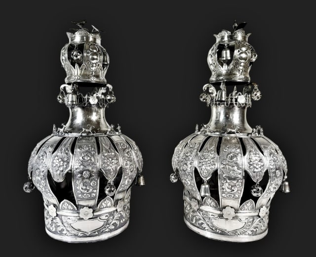 Pair of Antique Silver Torah Crowns (2pc): Pair of Antique Continental Silver Torah Crowns. Traditional form, " Kedarim", with profuse floral and foliate repousse and hand chased embellishment with suspended silver bells and balls. Open crown 