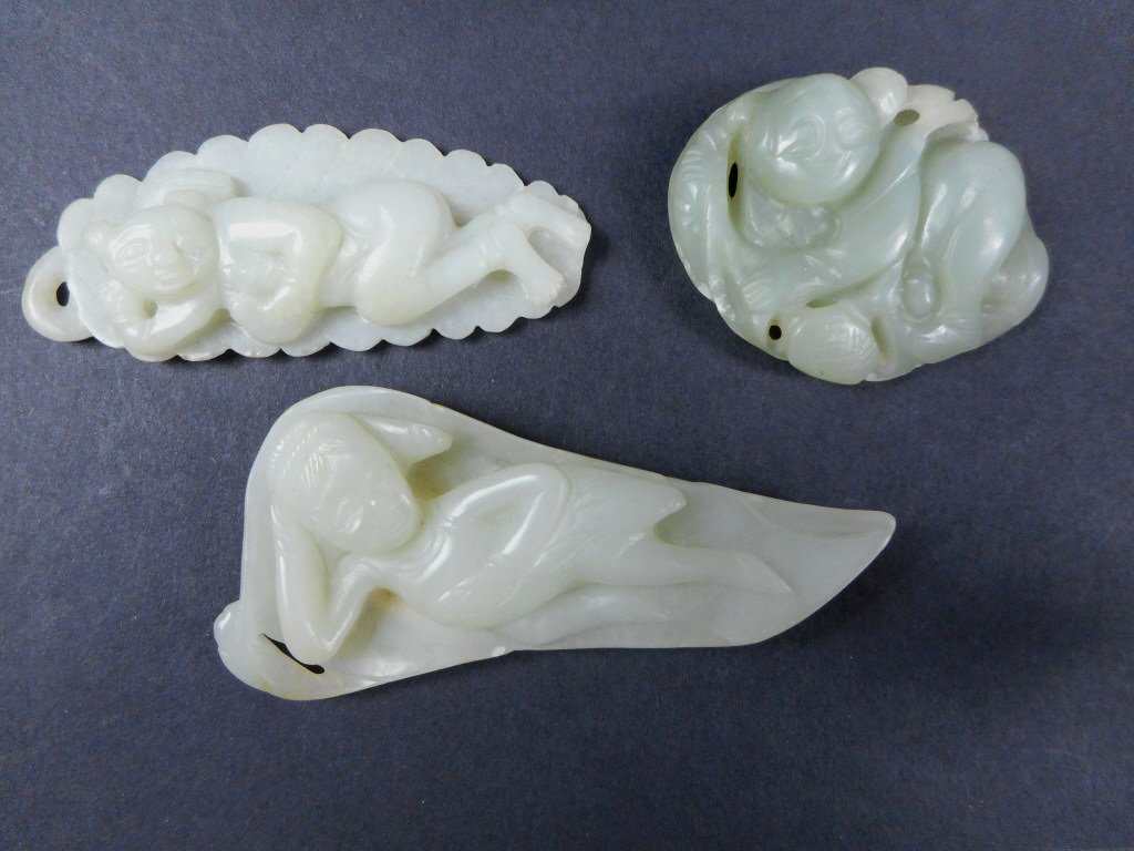 Three Jade Pendants: Collection of three white jade pendants depicts supine figures resting on a leaf bed, carved in bas-relief. Smooth polished surfaces. Slightly rounded carving is darker, greyish-white in color. Larges