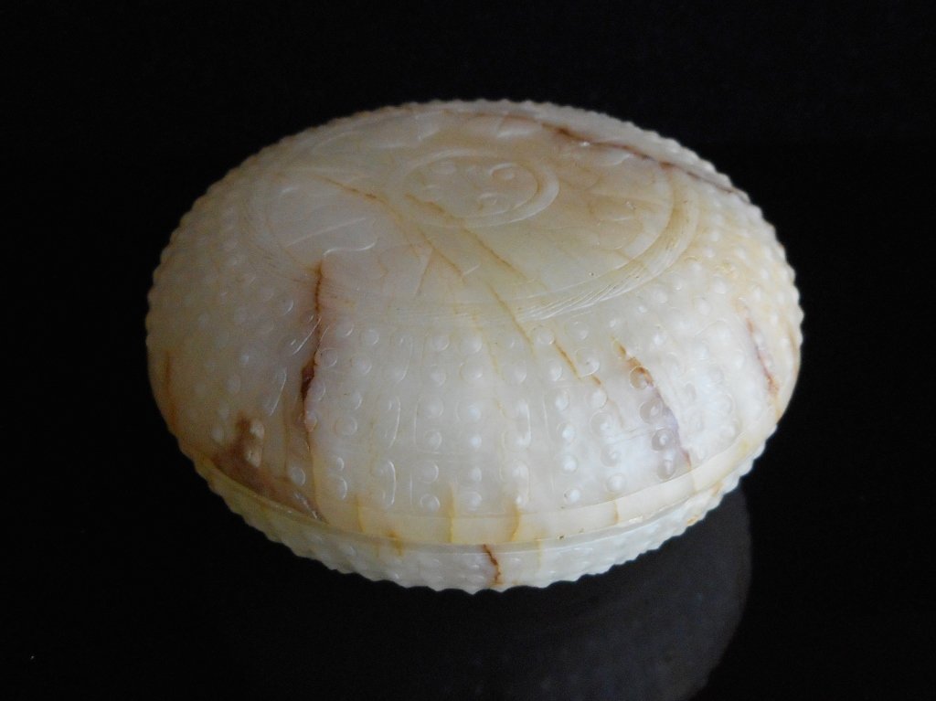 Lidded Jade Container: White jade round lidded container in cloud design pattern carved in relief. Smooth surface with tan colored suffusion, brown and russet veining throughout. 1.5"H x 3" D