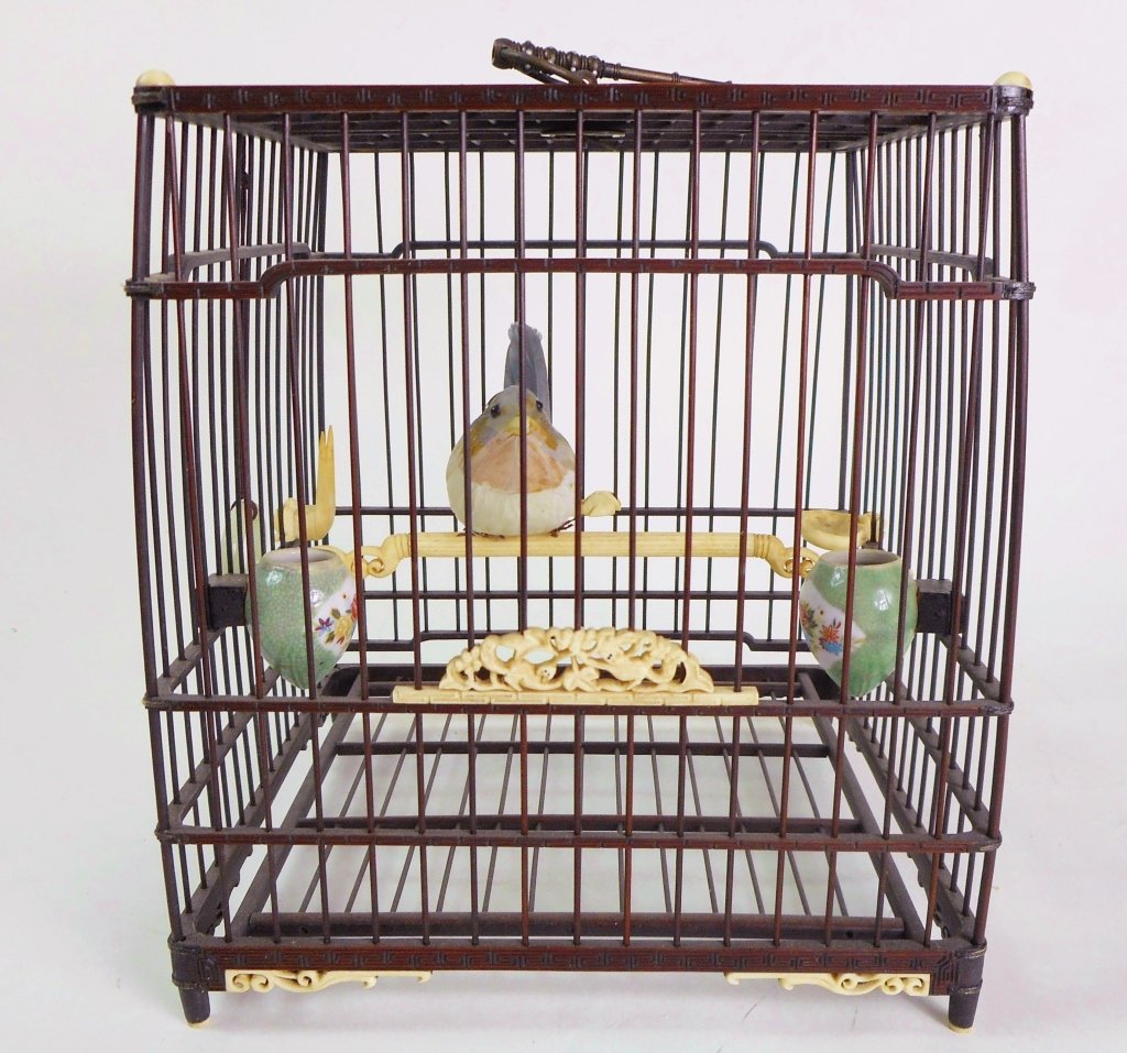 Antique Chinese Birdcage: Having carved bone perch and feeders, openwork design elements at base and door, two teardrop porcelain feeders, and a white jade ring suspended from a silk cord. 8.5'H x 7.25"W x 7.5"D_x000D_ _x000D_