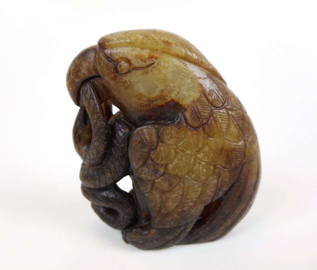 Jade Bird with Snake: Jade carving of a bird clutching a snake in his beak. Deep mahogany, brown and black suffusion, incised details. 2.25"H