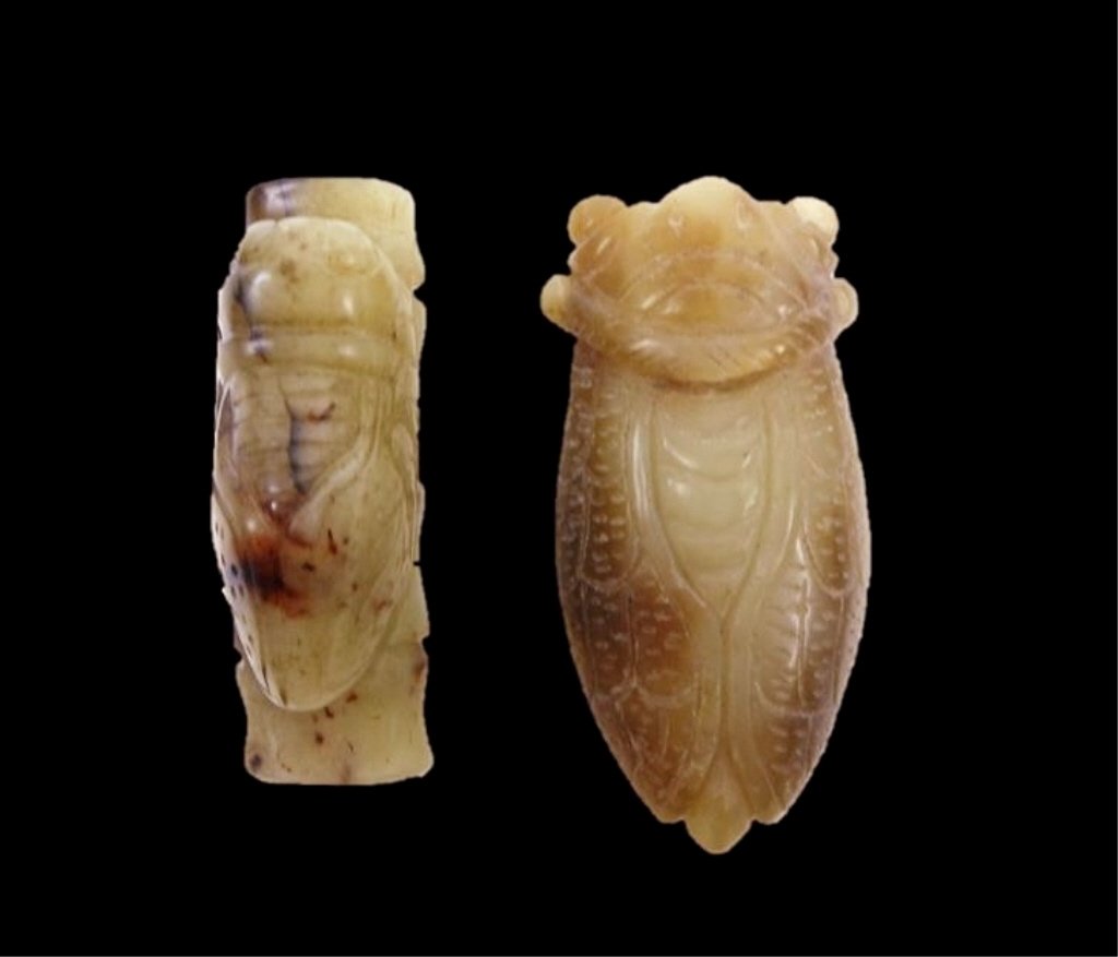 Two Jade Cicadas: One pale green toggle in the form of a cicada resting on a bamboo twig. Smooth surface with incised details, russet and brown suffusion. 2"L_x000D_ Together with a yellow-green carving of a cicada wit