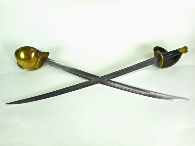 Two Civil War Navy Cutlasses, Ames Mfg Co: United States Navy, model 1860, signed on ricasso "Ames Mfg Co., Chicopee, Mass" with 1861 and 1862 dates. Single fullered curved steel blade with brass guard and leather grip. Grey steel blades. Leat