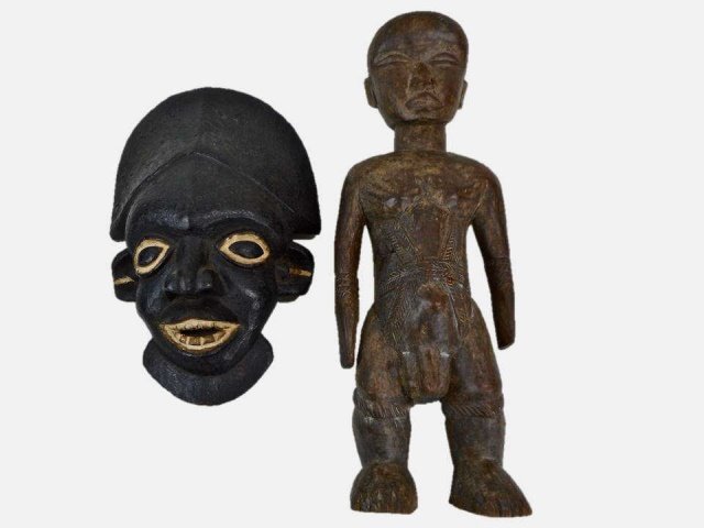 African Carved Wood Statue and Mask: Antique carved wood statue of a male figure with incised details. Natural cracks in wood with slight loss at nose and midsection. 25"H Together with a carved wood mask with open mouth. 18"H x 16"W.