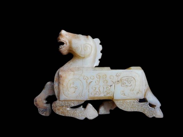 Antique Chinese Jade Horse Brush Rest: Antique Chinese jade brush rest in the form of a kneeling horse, having incised dragon and phoenix design with cloud and meandering thunder patterns on body. 4"H x 5.5"L Provenance: Private Massachuse
