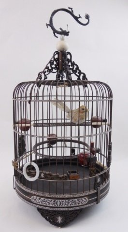 Antique Chinese Birdcage: Antique birdcage constructed of bamboo and inlaid bone, having five oxblood porcelain feeders, a jade ring, and openwork designs at base and top. Hanger is fashioned as a dragon. 20"H _x000D_
