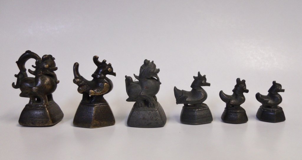 Six Antique Burmese Bronze "Opium" Weights: Collection of six antique bronze "opium" weights of the 18th and 19th centuries in hintha, kareweik and chinthe form carrying 6,9-ray star and bird marks. Largest measures 3"H.