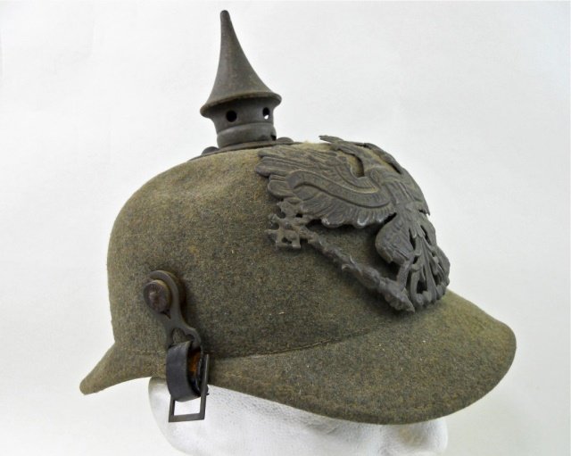 WWI Prussian Felt Picklehaube Helmet M1895: Felt body with steel Prussian eagle plate and spike with two metal posts and leather chinstrap. Interior with leather liner and crown plate secured by four split pins. Tear in back bill, body is missh