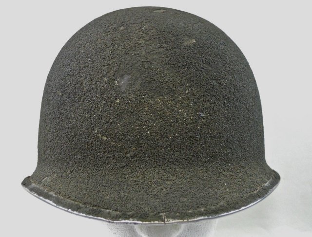 WWII M1 Fixed Bail Front Seam Helmet: Rough sand olive drab paint with fixed bails and front seam. Post war paratrooper liner with leather pad and "A" frame chin strap. Rim wear to finish 7.0" H x 9" W x 11" D