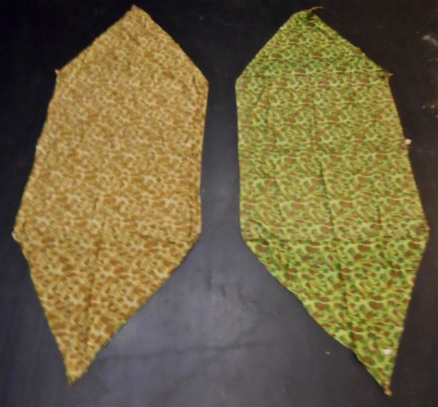 Two WWII USMC Camouflaged Shelter, Powers 1945: WWII Double sided camouflaged fabric with ties, metal grommets and buttons for attachment. One side with green based pattern with brown and olive drab with two shades of green. Reverse with brown base