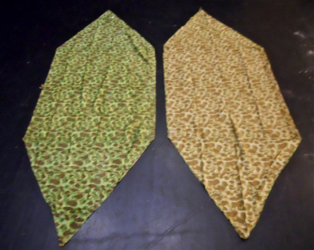 Two WWII USMC Camouflaged Shelter, Powers 1945: WWII Double sided camouflaged fabric with ties, metal grommets and buttons for attachment. One side with green based pattern with brown and olive drab with two shades of green. Reverse with brown base