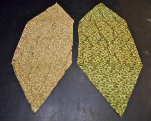 Two WWII USMC Camouflaged Shelters, Unit Marked: WWII Double sided camouflaged fabric with ties, metal grommets and buttons for attachment. One side with green based pattern with brown and olive drab with two shades of green. Reverse with brown base