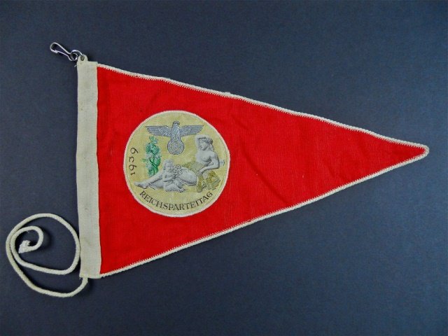 WWII German Double Sided Pennant, REICHSPARTEITAG: Silk rayon construction with machine sewn beVo woven medallion depicting supine neoclassical woman with child surmounted by eagle clutching swastika in silver bullion thread. Field reads, "REICHSPARTE